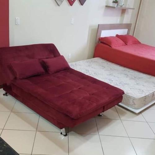 two beds with red cushions in a room at Loft Prainha 101, arraial do cabo in Arraial do Cabo