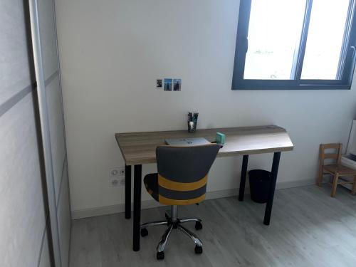 a desk with a chair in a room at Chambre chez l'habitant à 7kms du circuit des 24h in Laigné-en-Belin