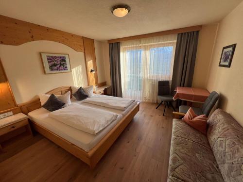 a hotel room with a bed and a desk at Adlerhof am Sonnenplateau in Mieming