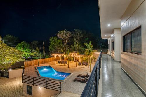 an outdoor deck with a swimming pool at night at Muna Santa Rosa Apartamentos in Tamarindo