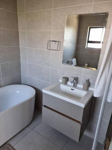 y baño con lavabo, aseo y espejo. en Crestline2 at Emeraldskye en Lombardy East