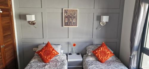 a room with two beds with orange pillows at Casa De Nefertiti in Playa Blanca