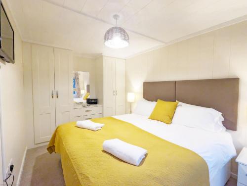 a bedroom with a large bed with two towels on it at Elm Lodge in Bosham