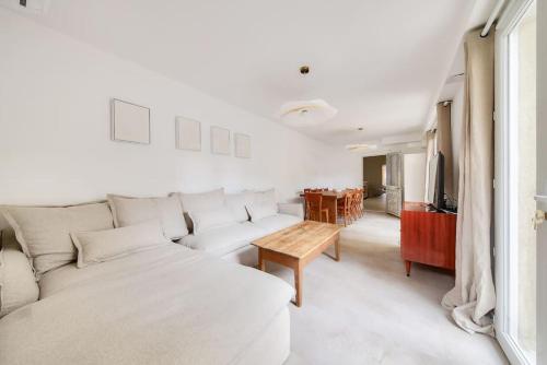 a white living room with a couch and a table at NOCNOC - Le Zellige - Petite piscine et jardin en ville in Montpellier