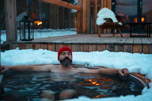 a man in a hot tub in the snow at Humno in Nová Baňa