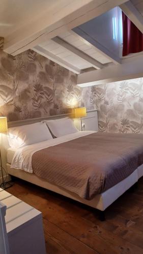 a bedroom with a large bed with two lights on it at B&B Opera Prima in Verona