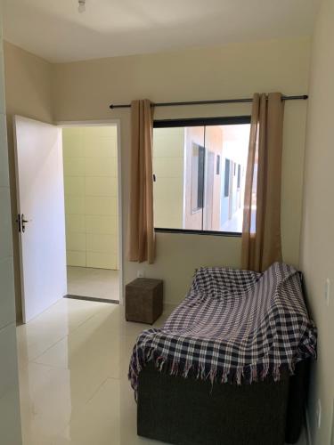 a bedroom with a bed and a sliding glass door at Mini Casa 02 em Cabo Frio in Cabo Frio