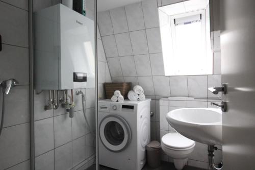 a bathroom with a washing machine and a sink at Moderne Dachgeschosswohnung mit 2 Schlafzimmern in Würzburg