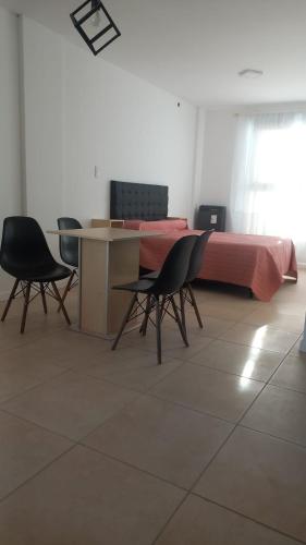 1 dormitorio con 1 cama con sillas y mesa en LAS VICTORIAS HOME V en Río Cuarto