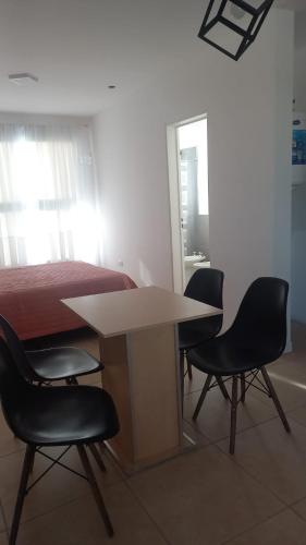 mesa y sillas en una habitación con cama en LAS VICTORIAS HOME V en Río Cuarto