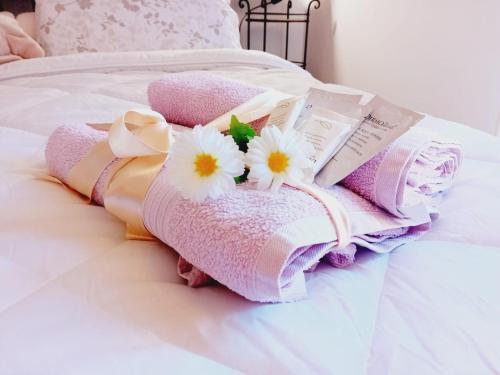 a pile of towels on a bed with flowers at B&B La Delice in Dalmine