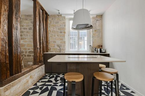 une cuisine avec un comptoir et des tabourets dans l'établissement Pick A Flat's Apartment in Opéra - Rue Saulnier, à Paris