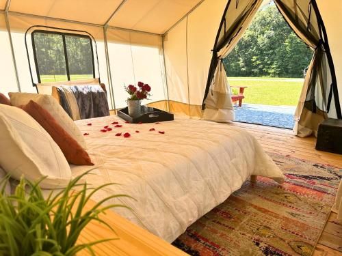 a bed in a tent with flowers on it at Couple's Glamping Tent - Roaring River in Cassville