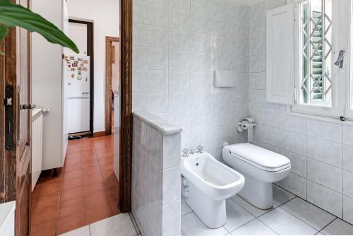 a white bathroom with a toilet and a window at A due passi dal Duomo di Firenze in Florence