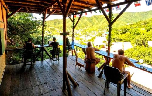 a group of men sitting on a deck with a view at Tamarindo Beach hostel in Taganga