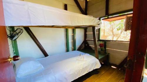 Tamarindo Beach hostel في تاجانجا: غرفة نوم مع سرير بطابقين في غرفة