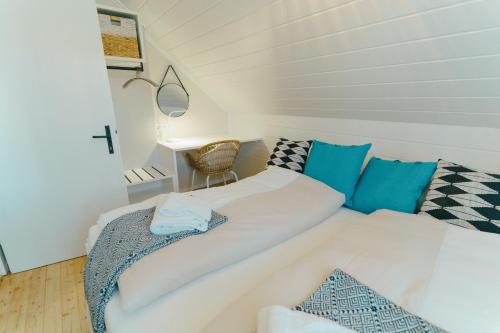 - un canapé blanc avec des oreillers bleus dans l'établissement seehaus ausZEIT, à Faak am See