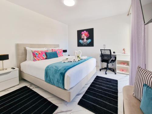 a white bedroom with a bed and a desk at Apartment Praia Rocha Vista Mar Seascape in Portimão