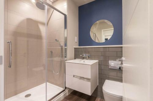 a bathroom with a shower and a toilet and a mirror at Rooms in Birmingham City Centre in Birmingham