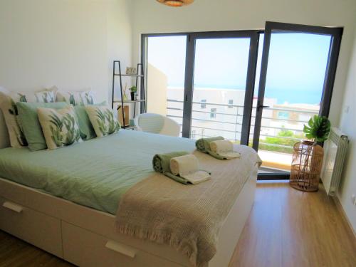 a bedroom with a bed with two towels on it at Casa Menezes in Lourinhã