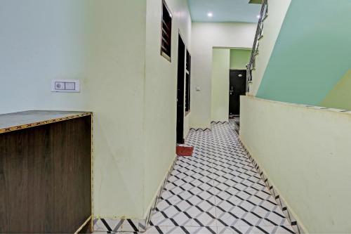 OYO D Ekant Hotel في Garhi Harsāru: ممر مع باب وأرضية من البلاط