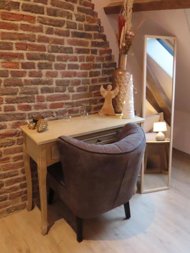 a desk with a chair next to a brick wall at B&B Den Bruynen Bergh in Beernem