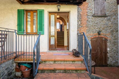 a cat sitting on the porch of a house at Casa Claire in Prataccio