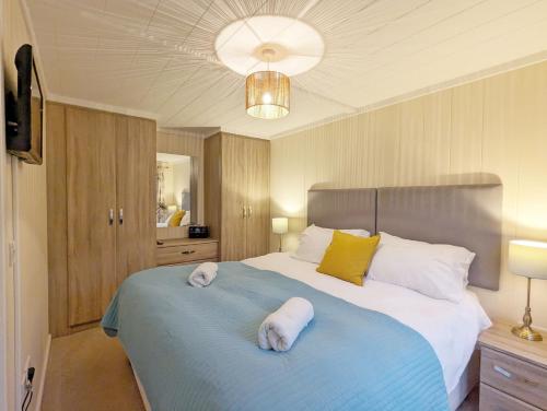 a bedroom with a large bed with two towels on it at Red Oak - Bosham in Bosham