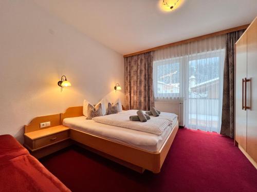 Habitación de hotel con cama y ventana grande en Appart Kofler en Gerlos