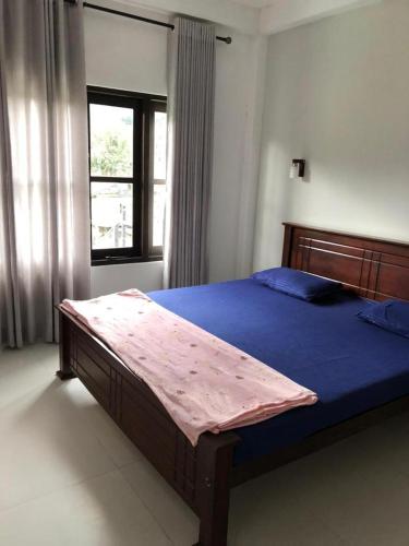 a bedroom with a bed with blue sheets and a window at Sun Villa 