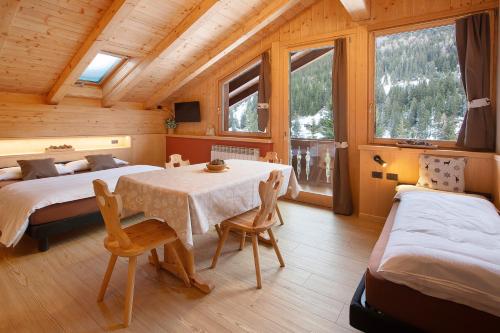1 dormitorio con 2 camas, mesa y sillas en Chalet Primula 13 en Santa Caterina Valfurva
