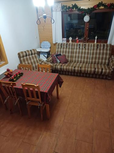 a living room with a table and a couch at Drevenica Západné Tatry s kúpacou kaďou a krbom in Žiar