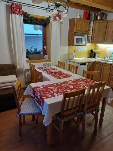 a kitchen with a table and chairs and a kitchen with a window at Drevenica Západné Tatry s kúpacou kaďou a krbom in Žiar