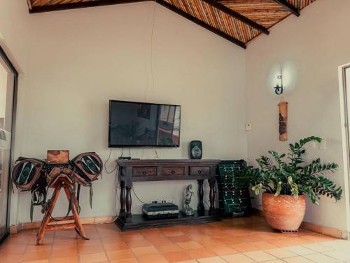 佩雷拉的住宿－finca turística DanuBio Alojamiento Rural Pereira Risaralda，一间设有电视的墙壁和一张三脚架的房间