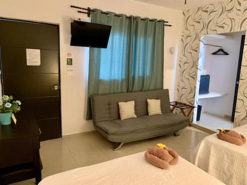sala de estar con 2 camas y sofá en Hotel La Casa del Capi en Holbox Island
