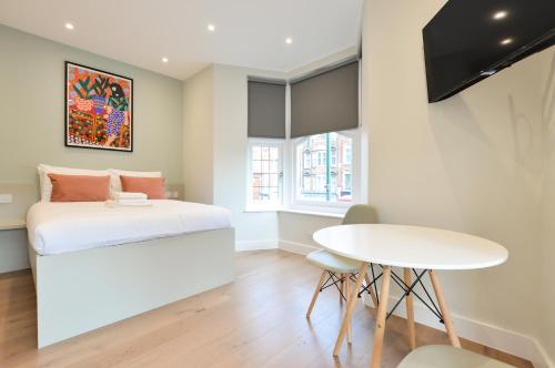 a small bedroom with a bed and a table at Golders Green Serviced Apartments by Concept Apartments in London