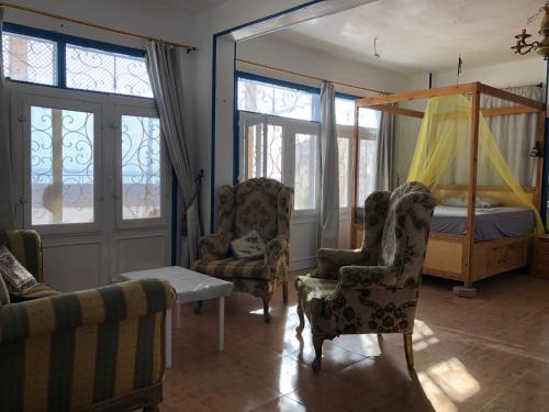 salon z łóżkiem i 2 krzesłami w obiekcie Das! Haus am Meer w mieście Safadża