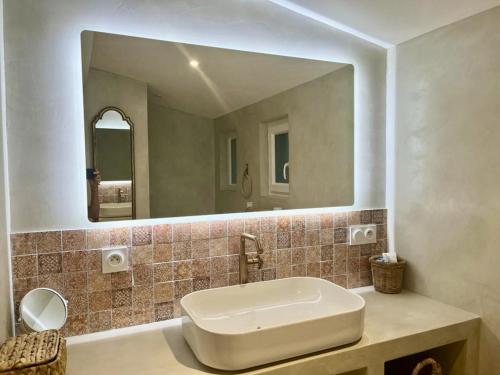 une salle de bain avec un lavabo et un grand miroir dans l'établissement Maison rénovée avec vue exceptionnelle sur le lac, à Lacanau