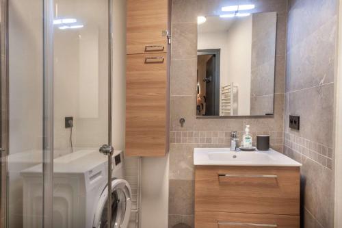 une salle de bain avec une machine à laver et un lavabo dans l'établissement CHALENDE 12 : Au coeur du village et à 200m des pistes, à Morzine