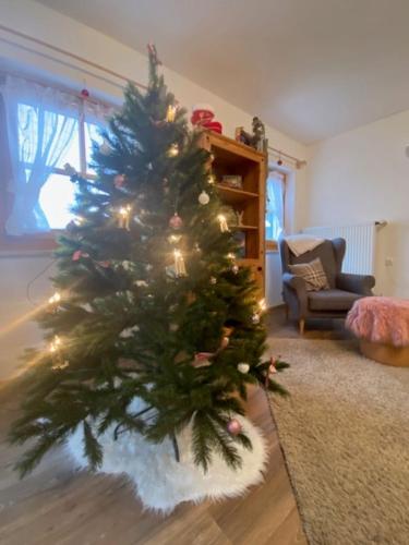 a christmas tree sitting in a living room with at Weber´s Fewo in Graswang