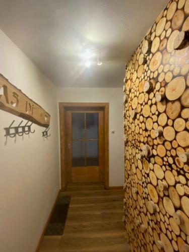 a hallway with a wall of logs and a door at Weber´s Fewo in Graswang