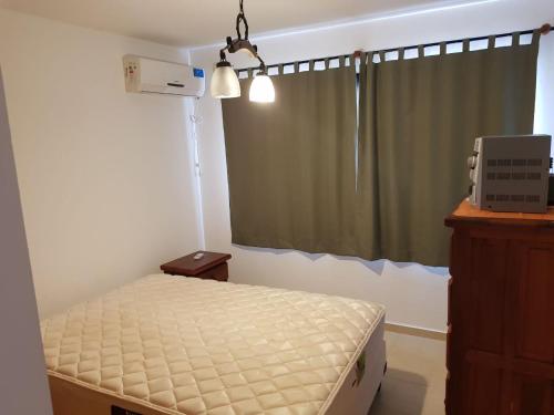 een kleine slaapkamer met een bed en een raam bij Terracota in Colón