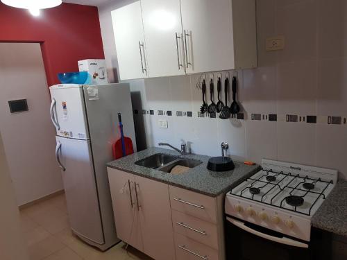 een keuken met een fornuis, een wastafel en een koelkast bij Terracota in Colón