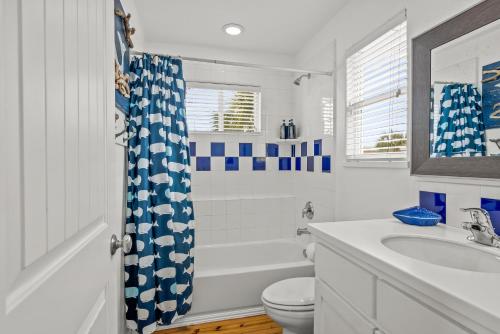 a bathroom with a tub and a toilet and a sink at Friday Life in Port Aransas