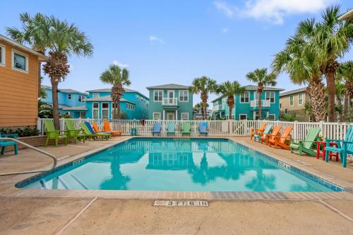 a swimming pool with chairs and palm trees at Friday Life in Port Aransas