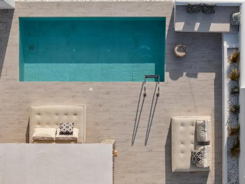 an overhead view of a swimming pool with two chairs at Villa Manikas Milos in Adamas