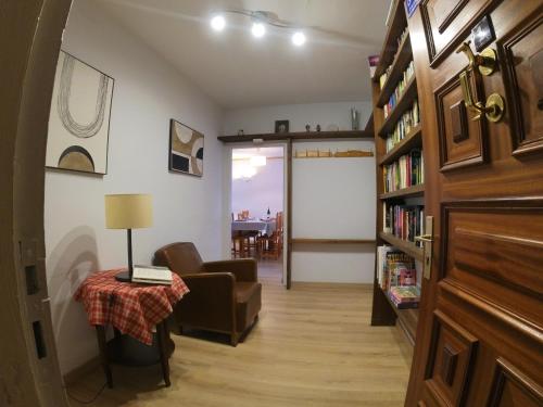 a living room with a table and a book shelf at Soldeu Paradis Soldeu in Soldeu