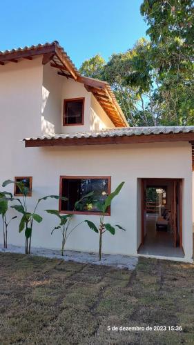 a white house with a tree in front of it at Casa Trancoso Refúgio in Trancoso