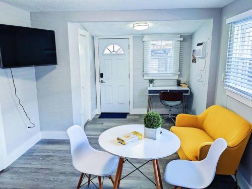 a living room with a table and a yellow couch at Elegant 1 Bed Montrose - Venice @ Italian Plaza in Houston
