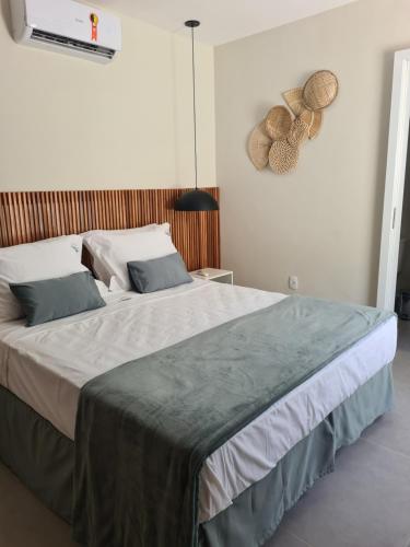 a bedroom with a large bed with two pillows at Brisas do Sul Condo Boutique in Pipa